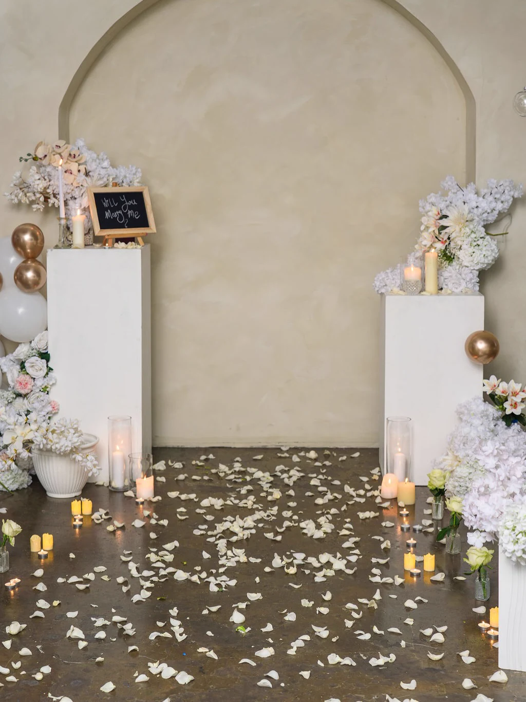 The arch set dressed with florals and candles for a proposal