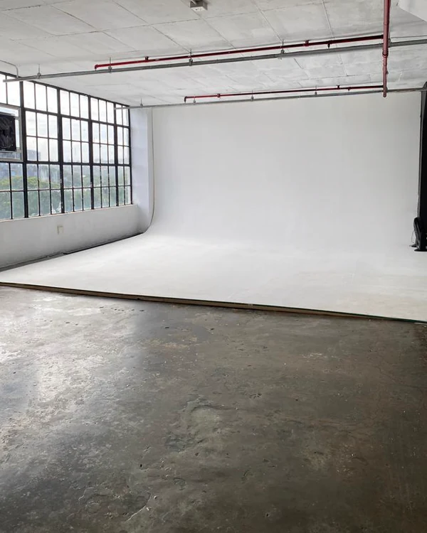 The raw studio floor with tall factory windows